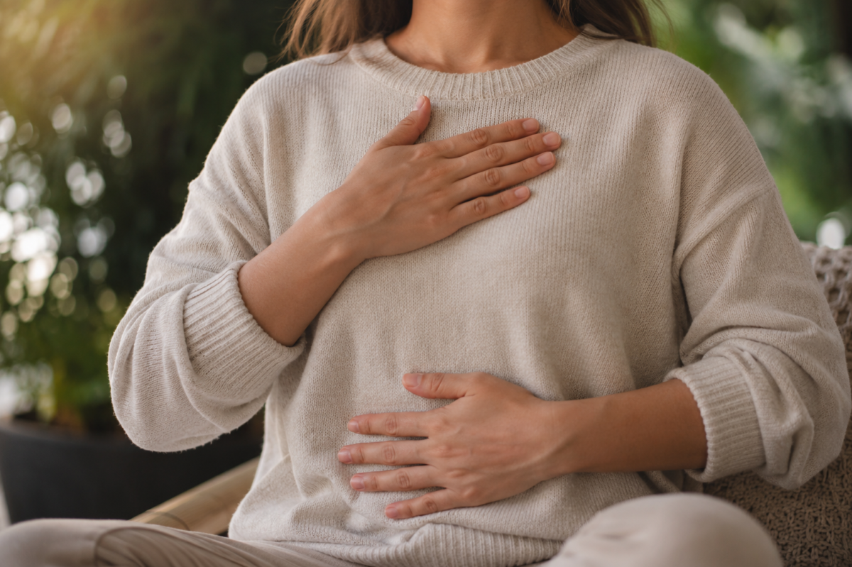 Hands resting on chest and belly during slow exhale led breathing for anxiety